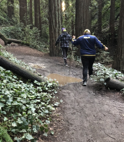 Hikers stepping around puddle on trail