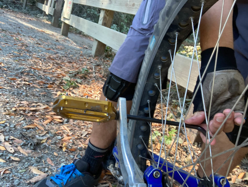 Using an Allen key to remove a pedal on a unicycle. 